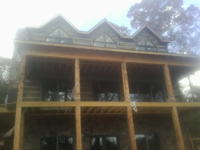 Dormers and porch framing on a large log home under construction — Roof Coating work by our crew in South Dayton