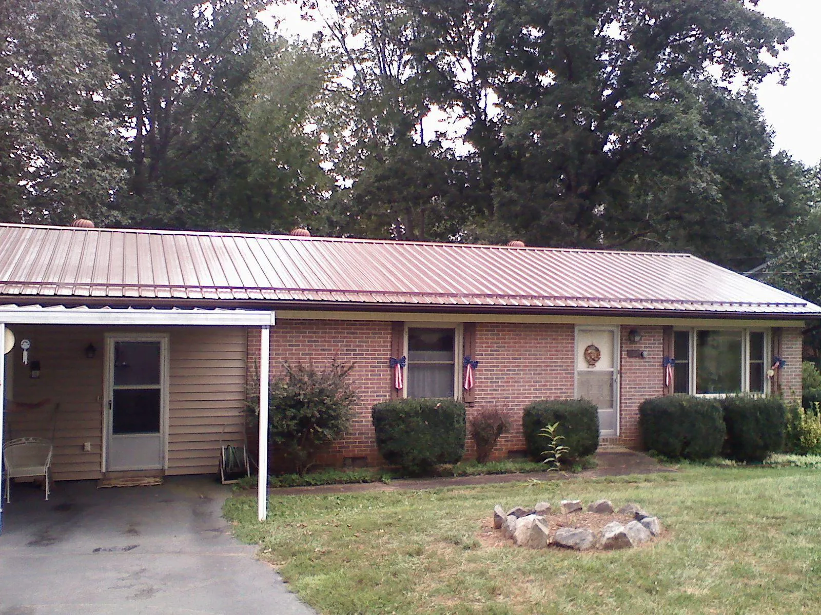 Bronze metal roof and carport on a brick ranch home — Roof Repair work by our crew in South Dayton